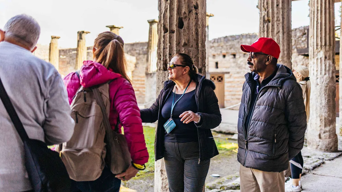 Coach travellers walking towards the Porta Marina entrance on a Pompeii day trip from Naples, Italy